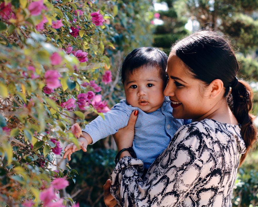 A mother holding her toddler among flowers in Kashmir
