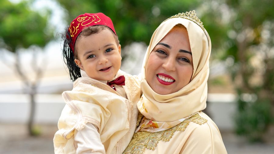 A hijab-wearing mother holding her toddler